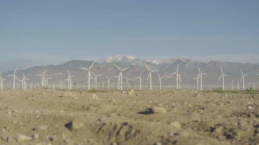 Turbines rotate on a wind farm in the desert