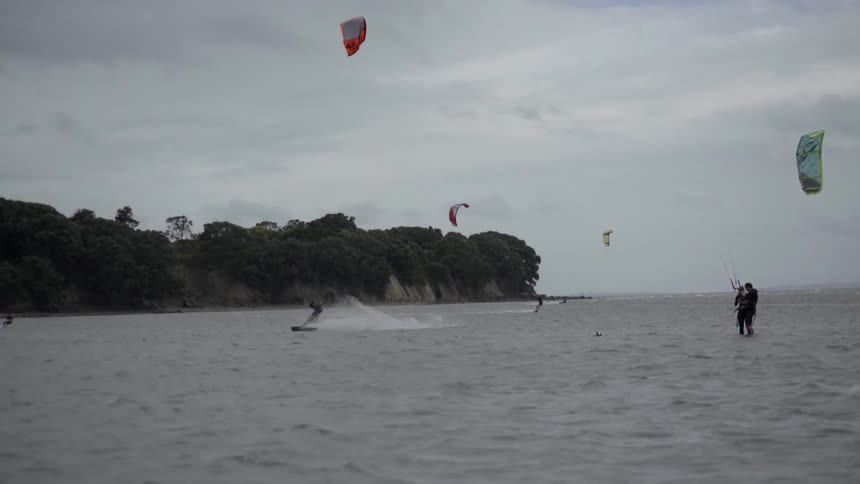 People water skiing and holding onto parasails