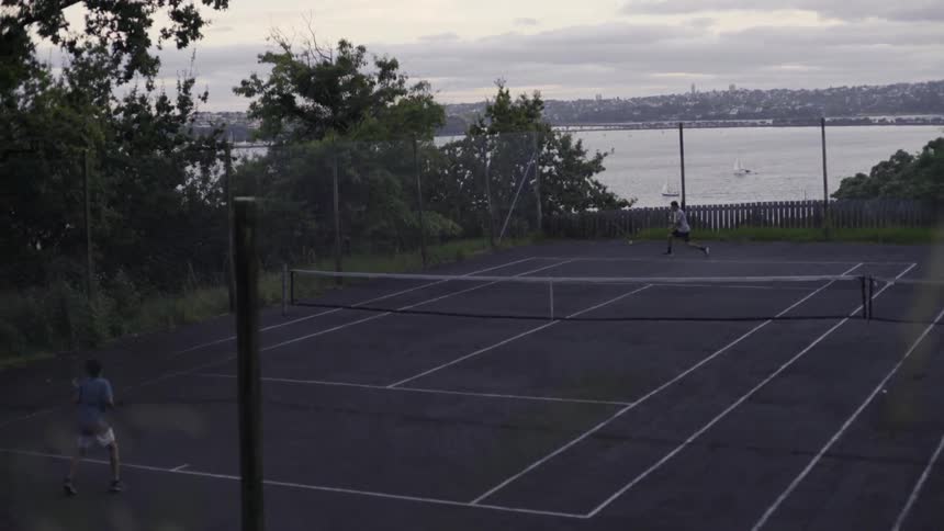 Friends Hitting Tennis Balls Outdoors In Lively Court Match Setting.