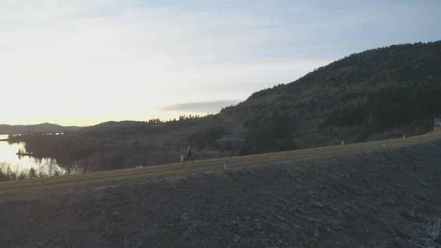 Girl running next to a mountain