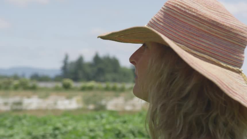 Woman in sunhat standing on a field