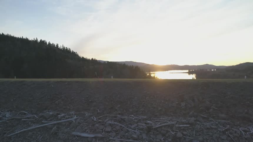 A person is running up the trail by the river