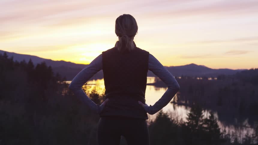 A woman stares into the sunset