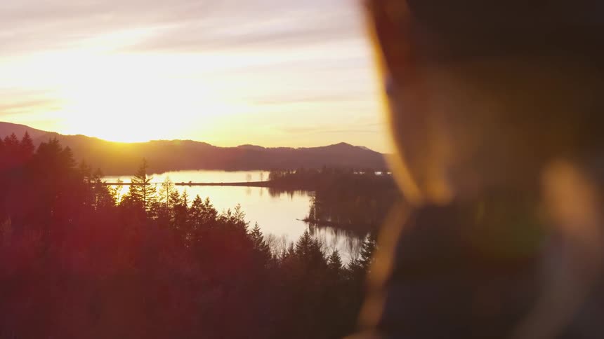 Woman contemplating sunset over the mountains