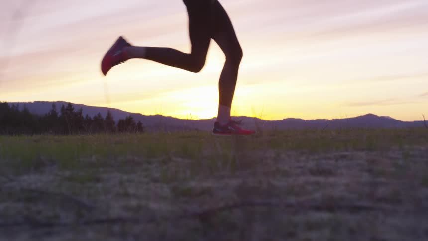 A person is jogging outdoors at dusk