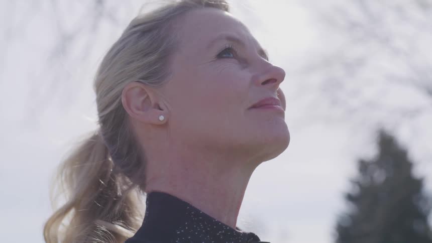 A woman outside staring at the sky