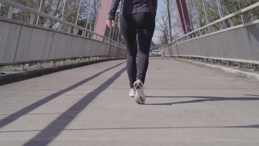 A woman is walking over an overpass