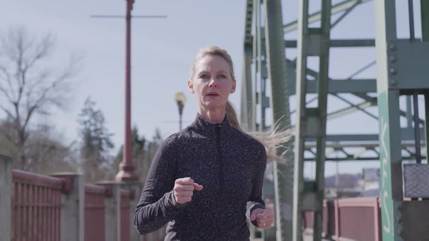 A woman runs along a sidewalk
