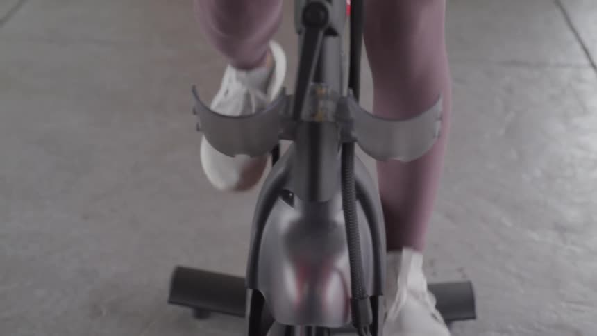 A woman rides a stationary bike