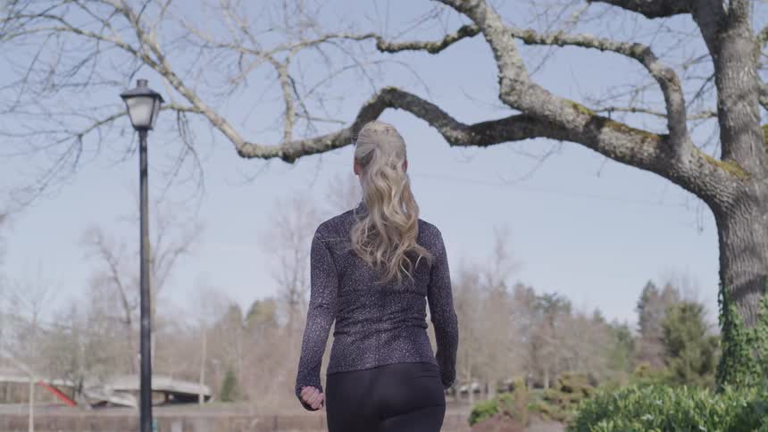 A woman outside walking in the park
