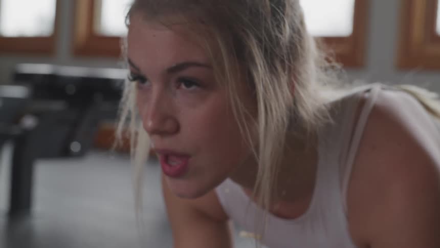 Blonde woman works out in gym during daylight