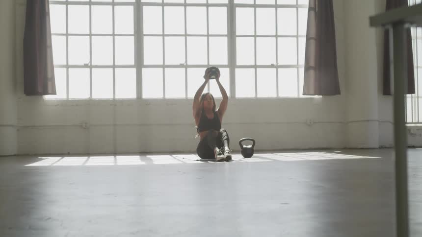 Woman exercising in fitness studio on the floor