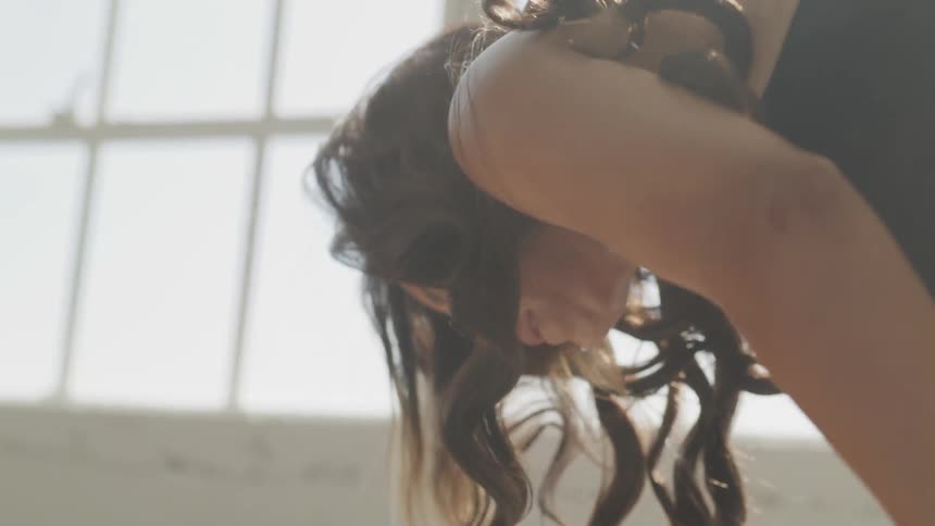 Brunette woman takes a break during workout indoors during daylight