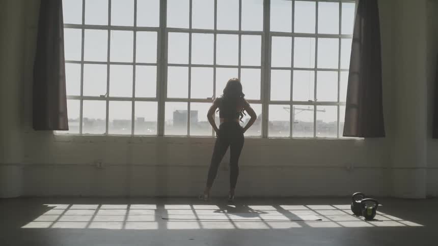 A woman is looking outdoors through a window