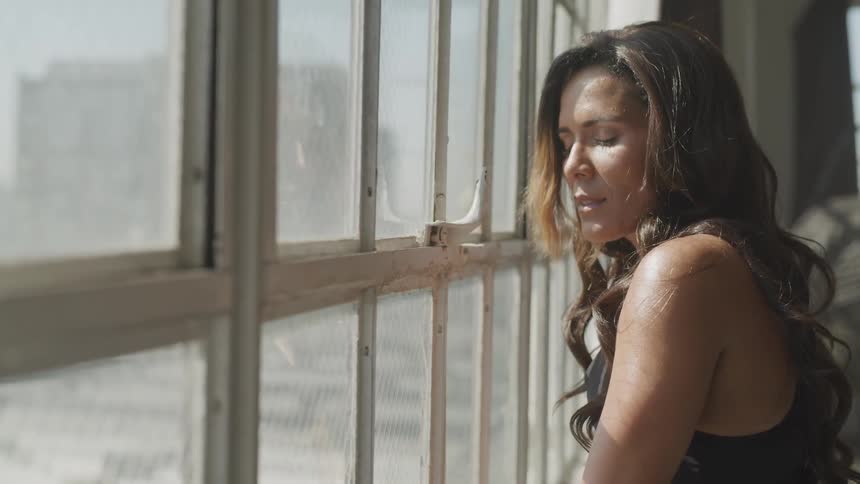 Girl in the sun next to the window