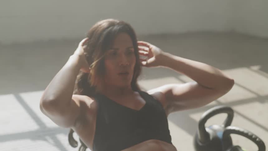 A woman does crunches on the floor