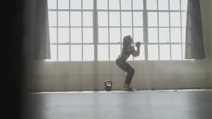 A young woman lifts weights