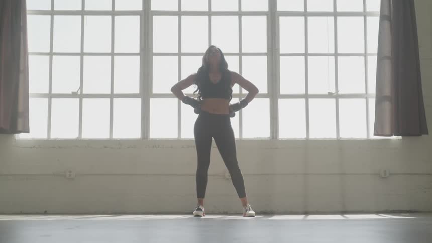 Woman exercising at the building near a big window