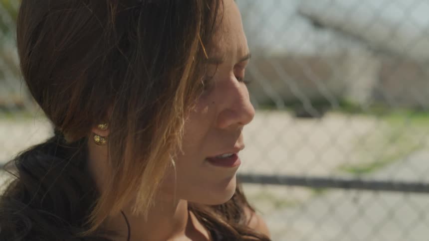 A young woman looks worried as she stands outside