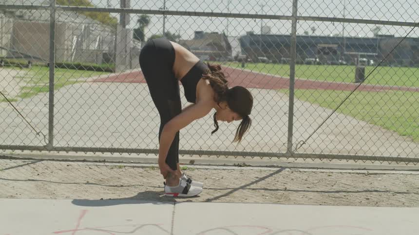 A woman is stretching outdoors