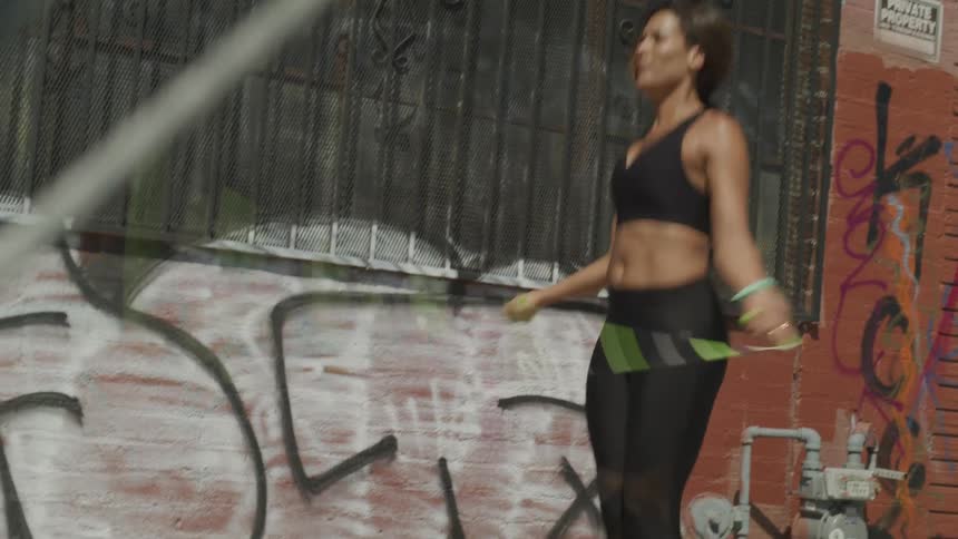 Woman jumping with skipping rope outdoors
