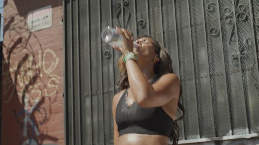 A woman is drinking out of a water bottle