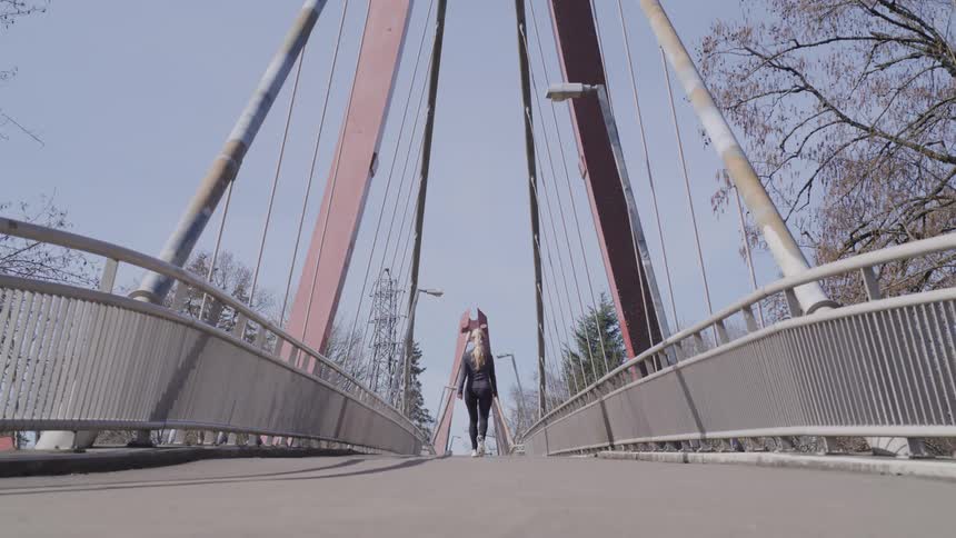 Girl walking across a bridge