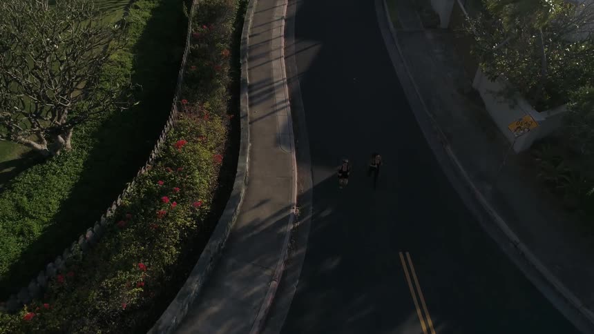 An aerial view of two women jogging on a street
