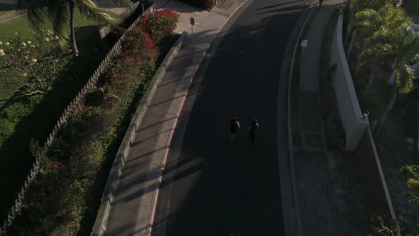 Runners traveling down the street in a neighborhood during the day