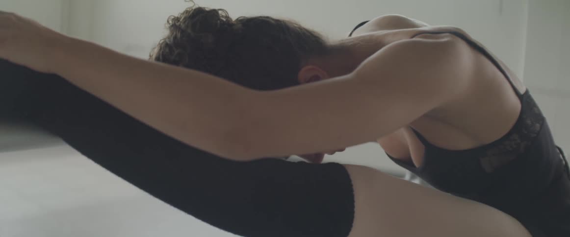A female dancer stretches forward and backward