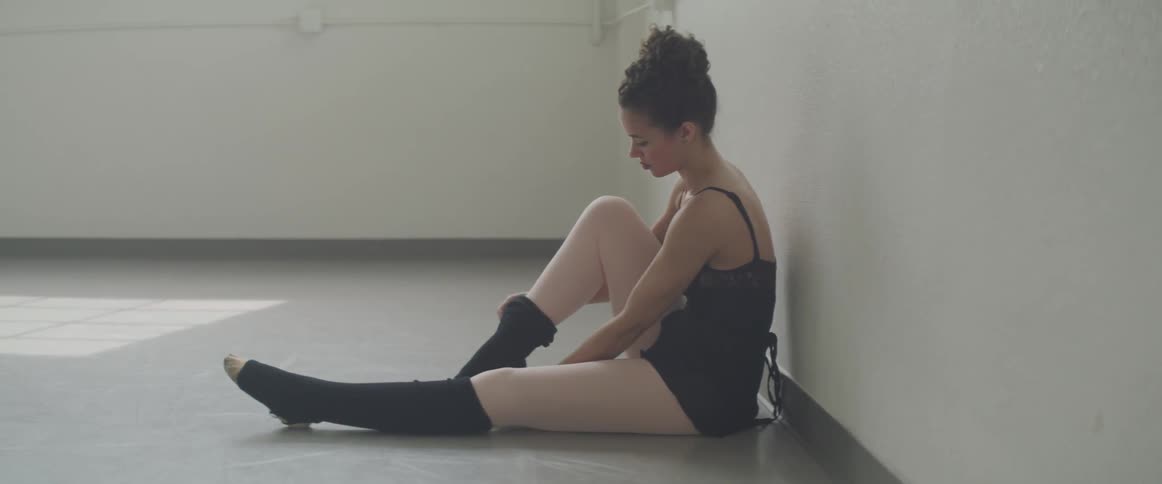 Girl putting on ballet socks on