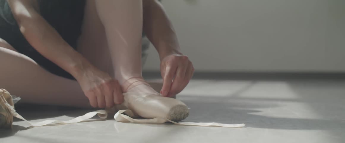 A ballerina puts on her shoes