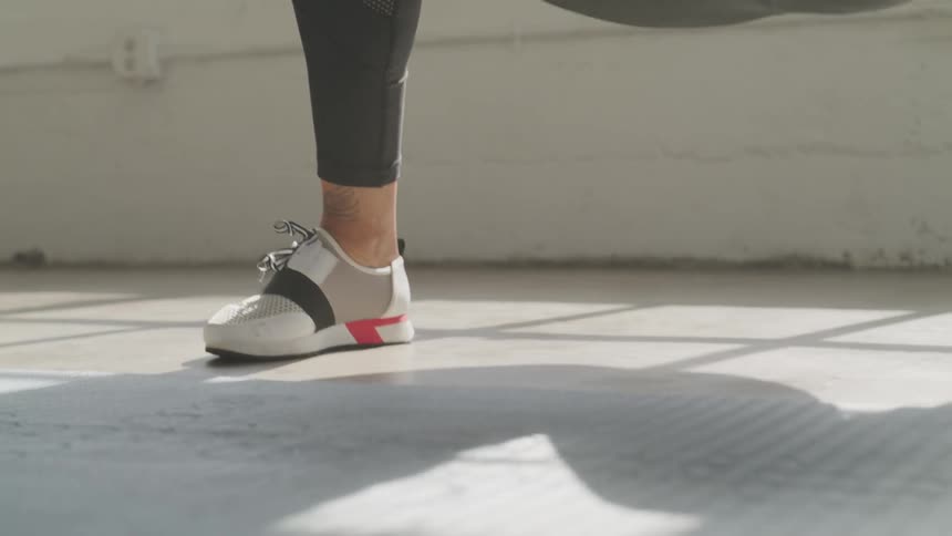 A woman bends and stretches her leg to the side