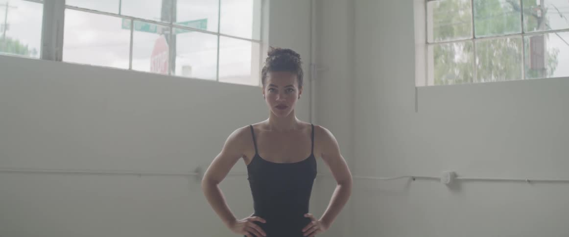 A woman with black tank top contemplating