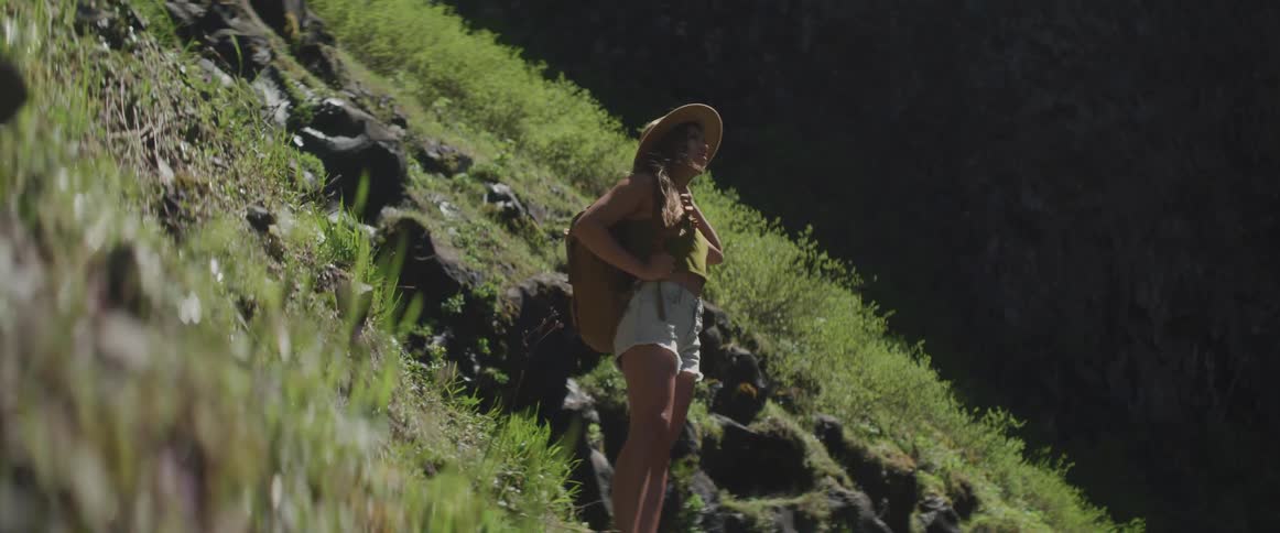 Girl standing next to a hillside