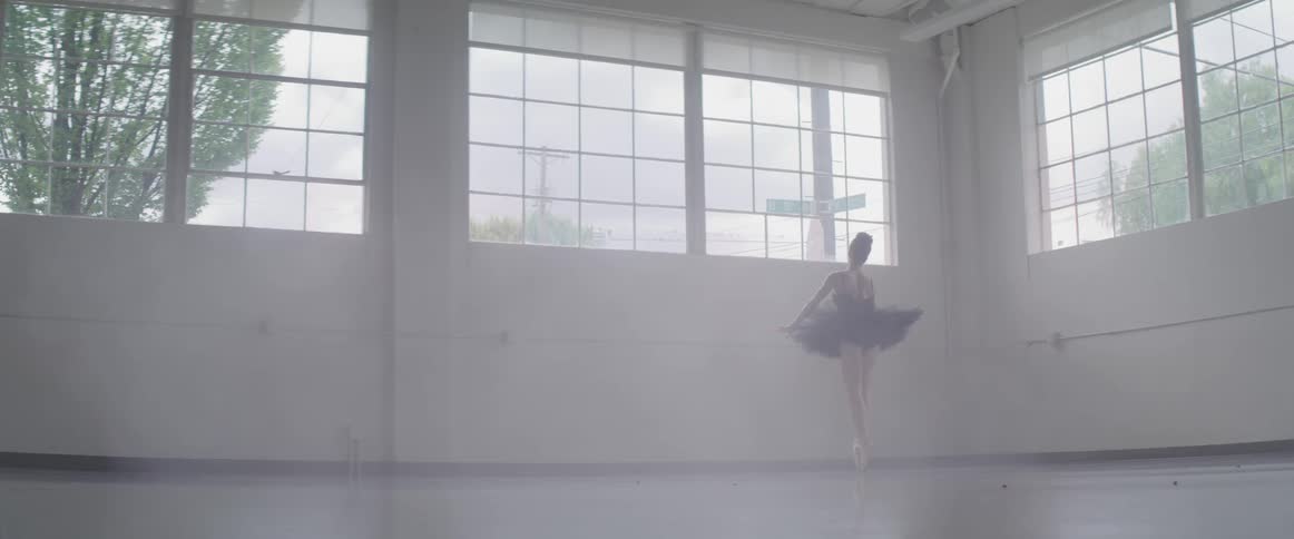 A ballerina raises her arms over her head as she dances and twirls on her toes