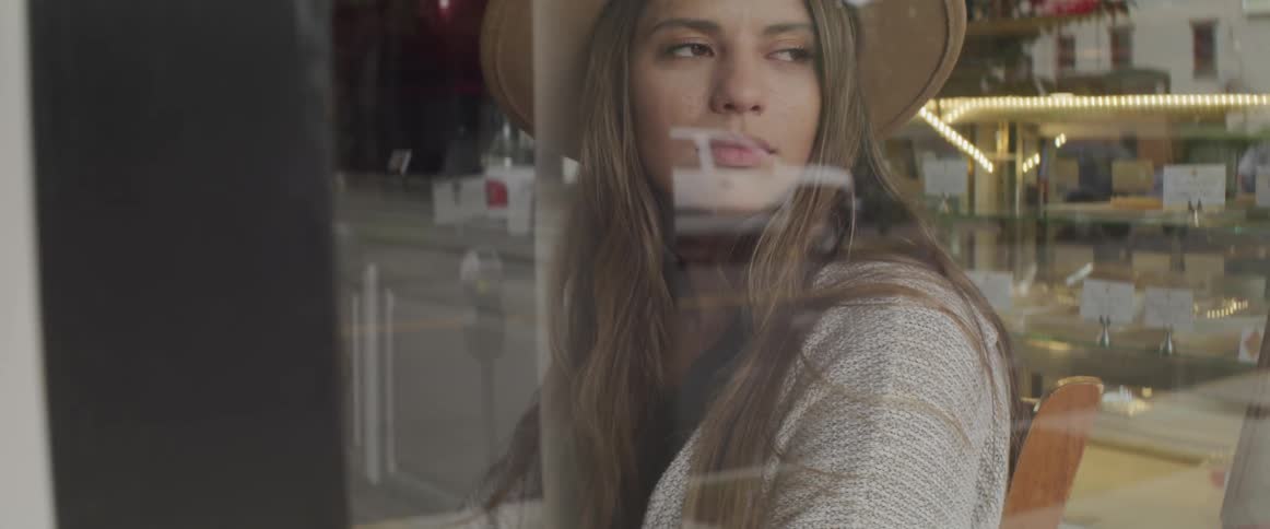 A woman is in a store wearing a hat