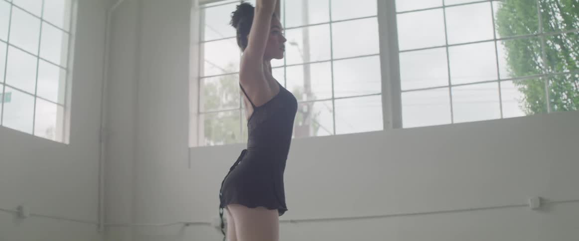 A woman twirls around and dances