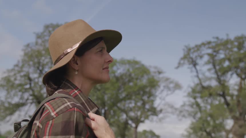 A woman stands outside and looks in to the distance