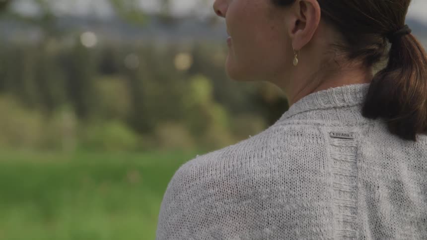 Woman on sweater standing on a grass field