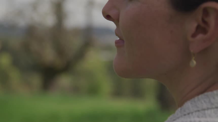 A woman sits outdoors in a park