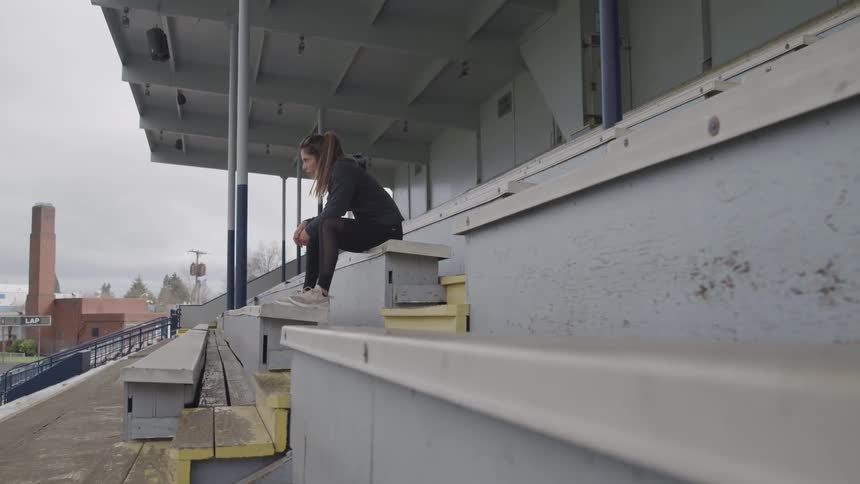 Girl sitting in the bleachers of a stadium