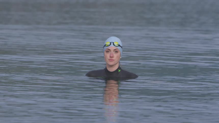 Woman with a swim suit swim alone in the middle of a river