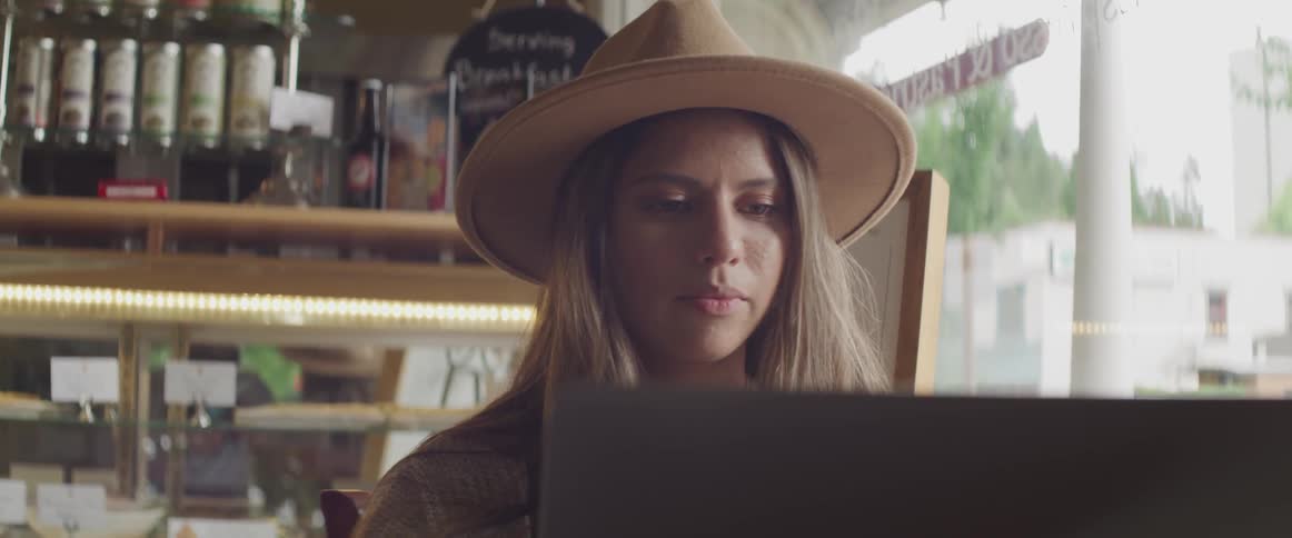 Girl looking at a computer wearing hat