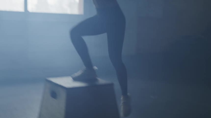 Woman exercises stepping up and down on platform