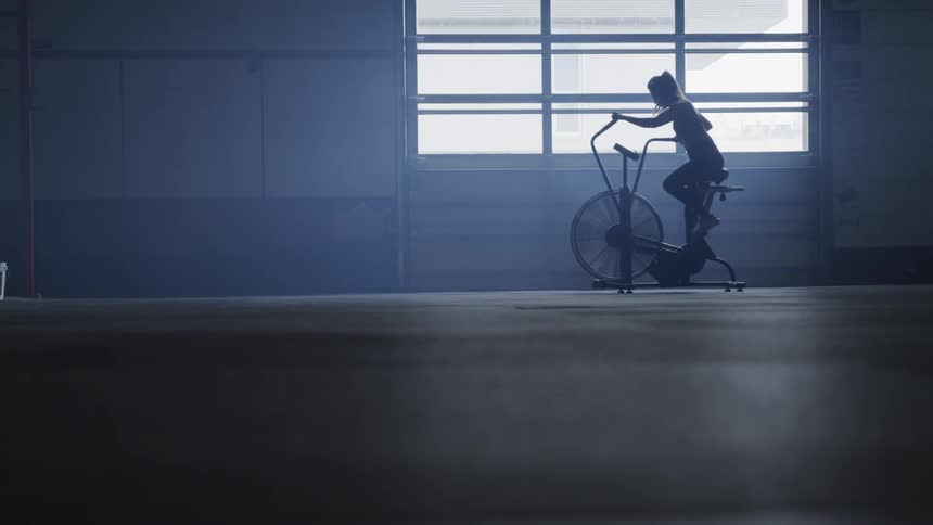 Woman is working out on an exercise bike