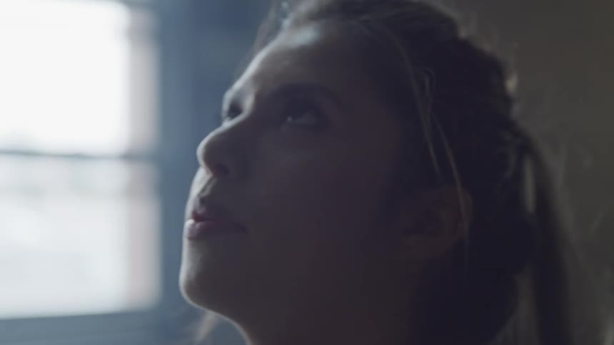 A woman breathes purposely as she looks at the ceiling
