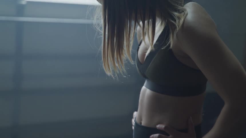 A woman breathing heavy while wearing fitness gear