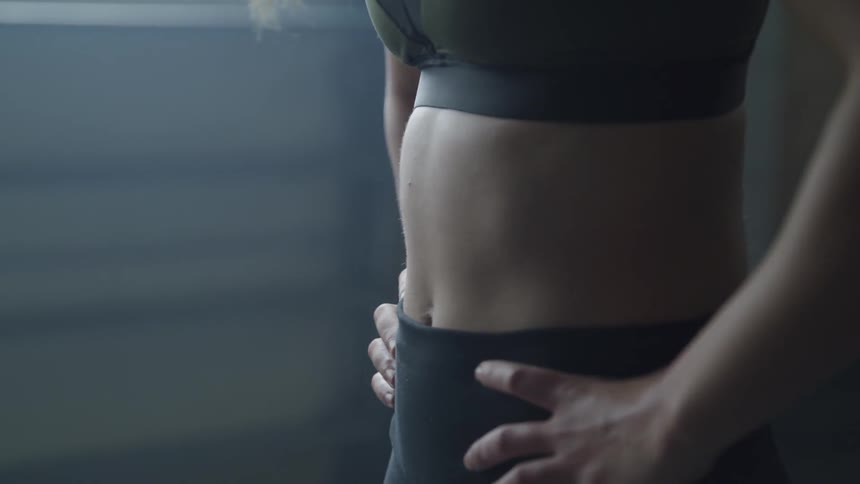 A woman wearing exercise clothing catches her breath