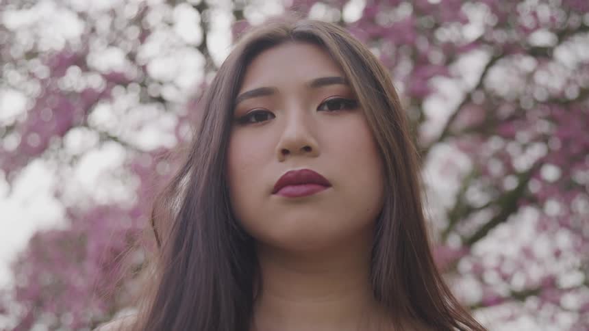 A young asian woman stares straight ahead